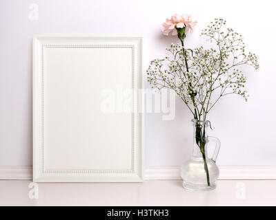 Cornice bianca mockup con fiori. Prodotto Poster design di stile mock-up. Foto Stock