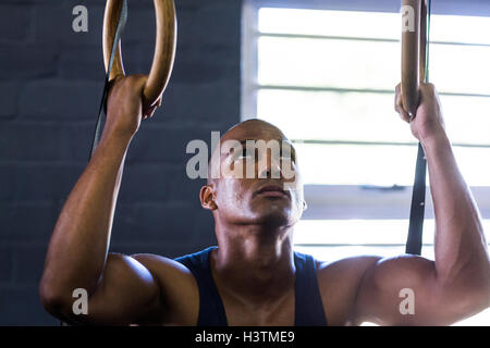Close-up di uomo con anelli di ginnastica in palestra Foto Stock