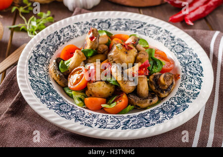 Caldo insalata di funghi con peperoncino e pomodori Foto Stock