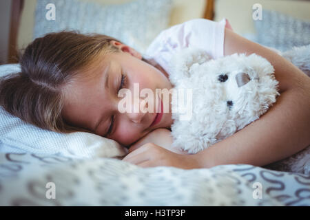 Ragazza distesa con un orsacchiotto di peluche Foto Stock