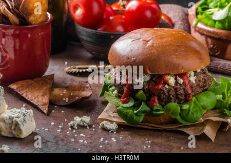 Hamburger di manzo con formaggio blu, in casa di nachos chips ed insalata Foto Stock