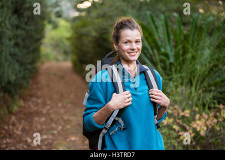 Escursionista femmina in piedi nella foresta con zaino Foto Stock