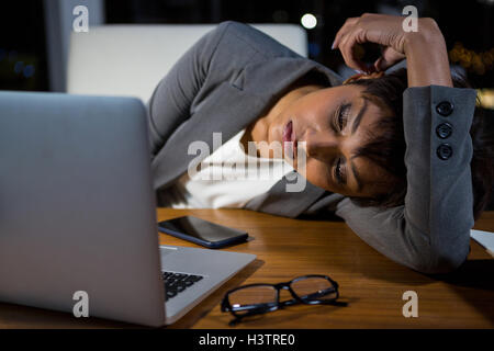 Stanco imprenditrice di dormire sulla scrivania Foto Stock