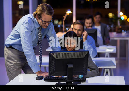 Imprenditore assistere il suo collega in ufficio Foto Stock