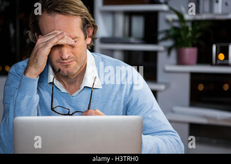 Imprenditore frustrato seduto in ufficio Foto Stock