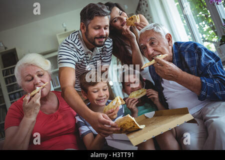 Multi-generazione famiglia avente la pizza insieme Foto Stock
