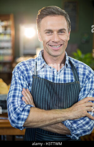 Ritratto di sorridere personale maschile in piedi con le sue mani incrociate Foto Stock
