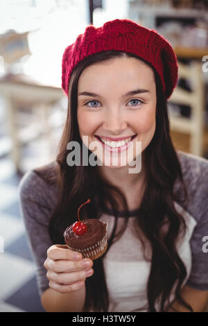 Ritratto di donna sorridente holding cupcake Foto Stock