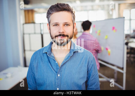Ritratto di imprenditore bello in piedi presso il creative office Foto Stock