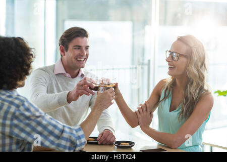 Sorridente amici avente una tazza di caffè nella caffetteria├⌐ Foto Stock