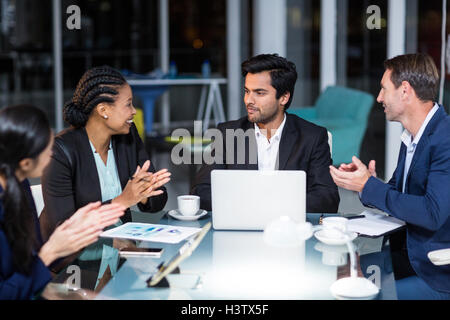 I colleghi ad applaudire un collega dopo la presentazione Foto Stock