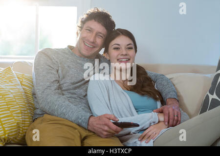 Paio di guardare la televisione mentre è seduto sul divano Foto Stock