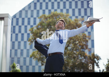 Imprenditore azienda blazer e giornale Foto Stock