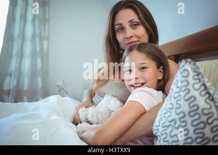 Madre giacente con la figlia sul letto Foto Stock