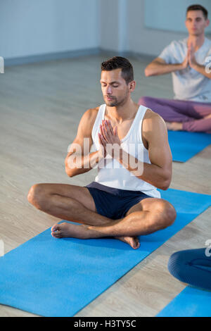 Giovane uomo di eseguire lo yoga Foto Stock