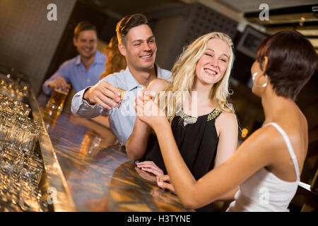 Il gruppo di amici una tostatura bicchieri di tequila shot Foto Stock