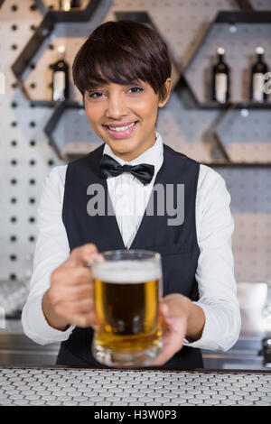 Barista che serve un bicchiere di birra Foto Stock