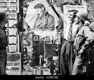 1940s uomo civile simbolicamente appeso ADOLF HITLER come due soldati YANK GUARDARE IL 26 AGOSTO 1944 NEL QUARTIERE LATINO DI PARIGI FRANCIA Foto Stock