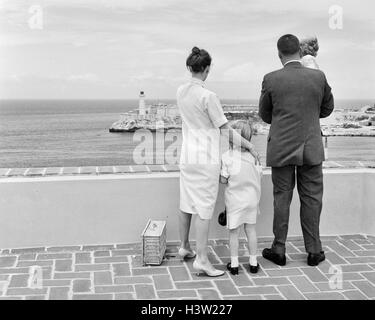 Anni sessanta VISTA POSTERIORE DELLA FAMIGLIA CERCA SU HAVANA HARBOUR CON MORRO CASTLE IN DISTANZA Foto Stock