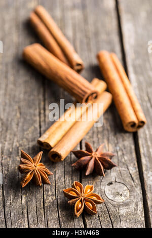 Bastoncini di cannella e anice stelle sul vecchio tavolo in legno. Foto Stock