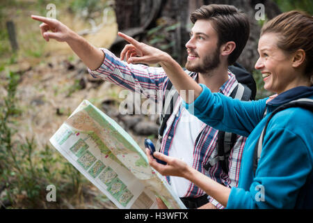 Escursionista giovane azienda mappa e che mostrano la direzione Foto Stock