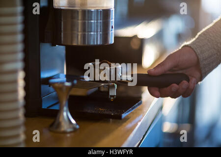 Cameriere azienda portafilter riempito di caffè macinato Foto Stock