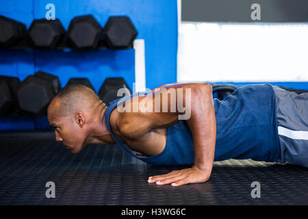 Vista laterale di atleta maschio facendo push-up Foto Stock