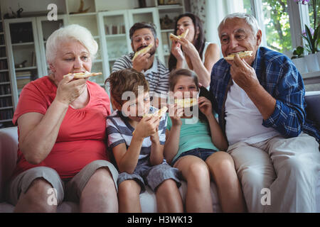 Multi-generazione famiglia avente la pizza insieme Foto Stock