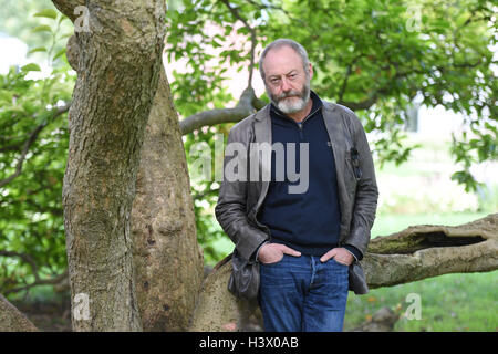 Stuttgart, Germania. Xii oct, 2016. Attore Liam Cunningham, che è noto come knight 'Ser Davos" dalla serie 'Gioco di troni', sorge tra i pilastri di Stoccarda (Germania), 12 ottobre 2016. A Stoccarda si è incontrato con il rifugiato siriano boy Hussam Al-Heraki. L'attore aveva avuto modo di conoscere il ragazzo quando ha visitato un campo di rifugiati in Giordania con l'organizzazione di aiuti World Vision. Foto: MARIJAN MURAT/dpa/Alamy Live News Foto Stock