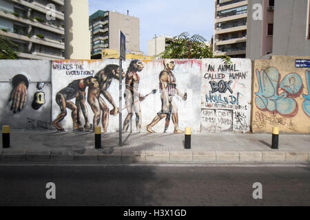 Beirut, Libano. Xii Ottobre, 2016. Un artista murale raffigura l'evoluzione da una scimmia per un uomo che indossa un suicidio giubbotto esplosiva tenendo un fucile da assalto Credito: amer ghazzal/Alamy Live News Foto Stock