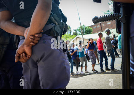 Johannesburg, Sud Africa. Xii oct, 2016. Poliziotti di stare di fronte al canto e ballo gli studenti dell Università di Witwatersrand (l ingegno) al di fuori di Hillbrow magistrato corte come gli studenti di attendere per i detenuti agli studenti di essere rilasciato a Johannesburg, Sud Africa, il 12 ottobre 2016. La recente ondata di proteste degli studenti ha continuato per settimane poiché le università hanno dato la luce verde da parte del governo il mese scorso per sollevare le tasse di iscrizione, a condizione che essa non ecceda il 8%. Credito: Zhai Jianlan/Xinhua/Alamy Live News Foto Stock