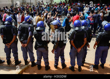 Johannesburg, Sud Africa. Xii oct, 2016. Poliziotti di stare di fronte al canto e ballo gli studenti dell Università di Witwatersrand (l ingegno) al di fuori di Hillbrow magistrato corte come gli studenti di attendere per i detenuti agli studenti di essere rilasciato a Johannesburg, Sud Africa, il 12 ottobre 2016. La recente ondata di proteste degli studenti ha continuato per settimane poiché le università hanno dato la luce verde da parte del governo il mese scorso per sollevare le tasse di iscrizione, a condizione che essa non ecceda il 8%. Credito: Zhai Jianlan/Xinhua/Alamy Live News Foto Stock