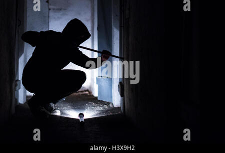 Rottweil, Germania. 8 Ott, 2016. Illustrazione - un ladro fittizia interruzioni aperta una porta con un jemmy nel seminterrato di una casa residenziale a Rottweil, Germania, 8 ottobre 2016. Foto: SILA STEIN/dpa (staged scena) © dpa/Alamy Live News Foto Stock