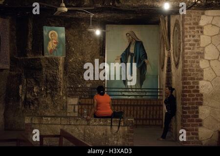 Assiut, Egitto. Undicesimo oct, 2016. Le donne egiziane pregare presso la Grotta Chiesa all'interno del Convento della Vergine Maria che si ritiene essere l'ultima fermata della santa famiglia in Alto Egitto, Dronka nella città di Assiut, Egitto, 11 ott. 2016. Il monastero della Vergine Maria a Al-Muharraq e il Convento della Vergine Maria sulla montagna di Assiut provincia nel sud Egitto stand come storici testimoni oculari di fuggire il viaggio della Santa Famiglia di Gesù Cristo e la sua madre vergine Maria e di san Giuseppe ad Alto Egitto oltre duemila anni fa. © Meng Tao/Xinhua/Alamy Live News Foto Stock