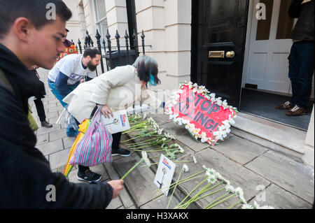 Londra, Regno Unito. Xiii oct, 2016. Manifestanti laici fiori bianchi e manifesti sui passi dell'Ambasciata delle Filippine. Essi esigono per Presidente Rodrigo Duterte fine i suoi ripetuti inviti per le forze di polizia e di pubblica per uccidere coloro che utilizzano e trattare la droga e ritirare la sua promessa non vi saranno azioni penali per queste esecuzioni extragiudiziali. Poiché Duterte arrivò al potere alla fine di giugno vi sono state oltre 3500 tali uccisioni illegali sulle strade. Credito: Peter Marshall / Alamy Live News Foto Stock