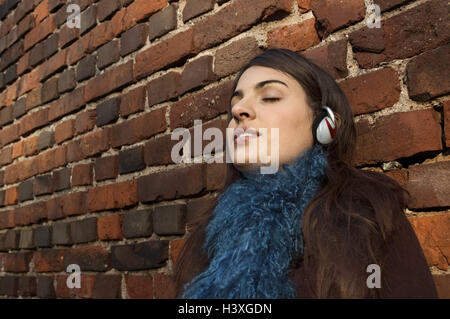 Adolescente, muro di mattoni, appoggia, cuffie, ascolta musica, gode, Ritratto, serie, 15-20 anni, dai capelli scuri, singolo, gli occhi a, chiuso i propri brani musicali preferiti, ascolta, rilassa Auszeit, hobby, tempo libero, Lifestyle, tuttavia al di fuori,, Foto Stock