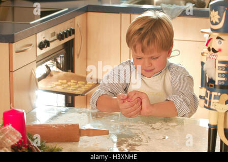 Yule tide, cottura, boy, pasta biscotto, impastare, ritratto, all'interno, a casa, la cucina, l'Avvento, tempo di Avvento, il periodo di Natale per Natale, Natale, elettrodomestico, preparazione, biscotti, pasta, torta di Natale, panettiere, dolce, biscotto e biscotti di Natale, bambino Foto Stock