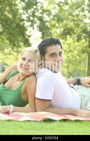 Giovane, prato, giacciono, estati, tappi, felice, donna bionda, uomo dai capelli scuri, 20-30 anni, giovani, ridere, riposo, take it easy, Nestle, magro, vicinanza, tenerezza, affettuosamente, all'esterno, tempo libero, parco, felice, cade nell'amore, solidarietà, week-end, visualizza fotocamera, colore umore, colore verde, pic-nic Foto Stock