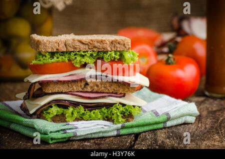 Sandwich freschi con carne affumicata, formaggio, lattuga e pomodoro con ketchup fatti in casa Foto Stock