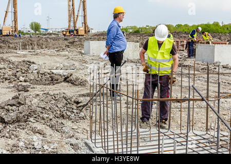 Di Zrenjanin, Vojvodina, Serbia - Giugno 14, 2015: i lavoratori sono la legatura rebar per effettuare un nuovo basamento costruito il telaio. Il legame concret Foto Stock