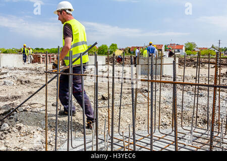 Di Zrenjanin, Vojvodina, Serbia - Giugno 14, 2015: i lavoratori sono la legatura rebar per effettuare un nuovo basamento costruito il telaio. Il legame concret Foto Stock