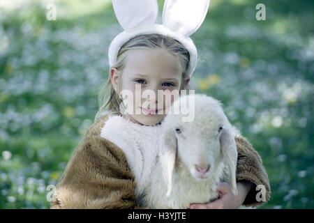 Prato, ragazza, lepre è costume, agnello, abbracciare, ritratto, pasqua, festa di Pasqua, bambino, infantile, infanzia, rivestimento, pannelli, costume, lepre le orecchie, agnello pasquale, Nestle, animale-amare, animale-amare, animale amicizia, ritratti di bambini Foto Stock