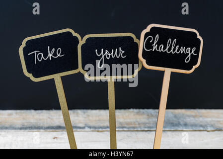 Messaggio motivazionale prendere la tua sfida scritto con un gessetto su legno mini etichette di Blackboard Foto Stock