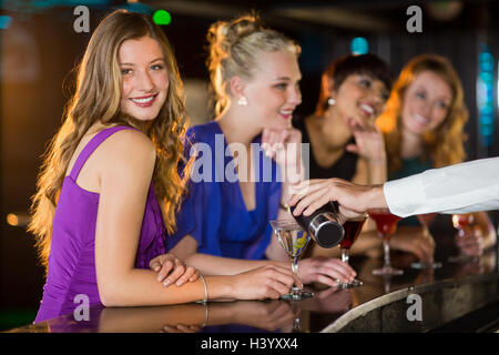 Cameriere cocktail di versatore in vetro womans al bancone bar Foto Stock