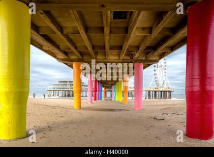 Basso angolo vista sul molo di Scheveningen con le sue colorate pilastri, sulla costa olandese di l'Aia, Olanda meridionale, Paesi Bassi. Foto Stock