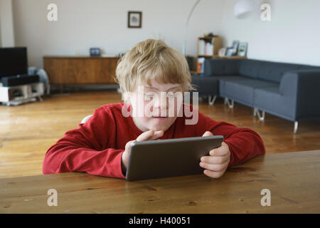 Disabled boy utilizzando tavoletta digitale in casa Foto Stock