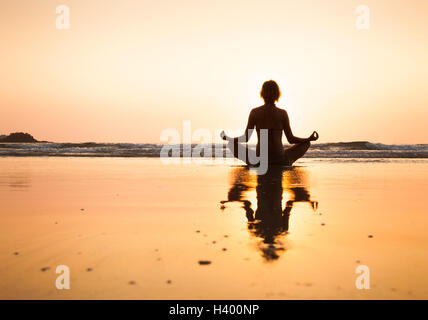 La donna a praticare yoga sulla spiaggia, posizione del loto a Koh Chang, Thailandia Foto Stock