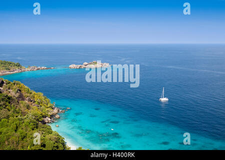 Isola tropicale circondata da trasparenti acque turchesi e le barriere coralline Foto Stock