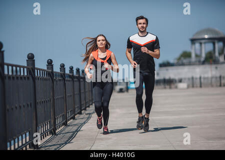 Lunghezza completa di determinate persone in esecuzione sul lungomare contro il cielo chiaro Foto Stock