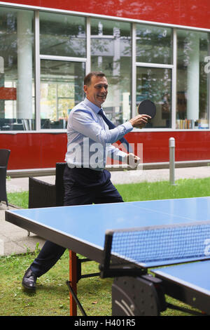Imprenditore giocando a ping-pong presso il creative office Foto Stock